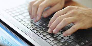 male hands typing on a laptop pc keyboard